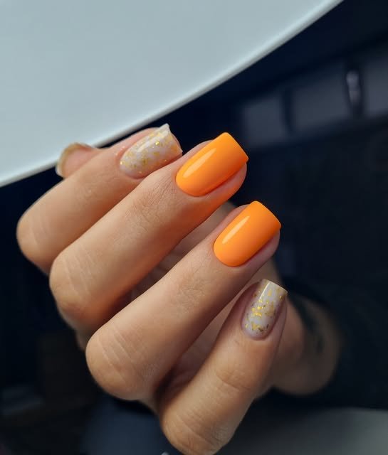 Manichiură portocalie cu accent glitter auriu
